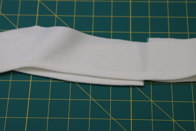 How To Hem Inner Curved Edge Of The Facing Pieces - Stretch Liverpool Knit - Mood Fabrics - Merano Balloon Sleeve Blouse Free Sewing Pattern Tutorial - MDF522 - Mood Fabrics Sewciety Blog - Hem the inner curved edge of the facing pieces.