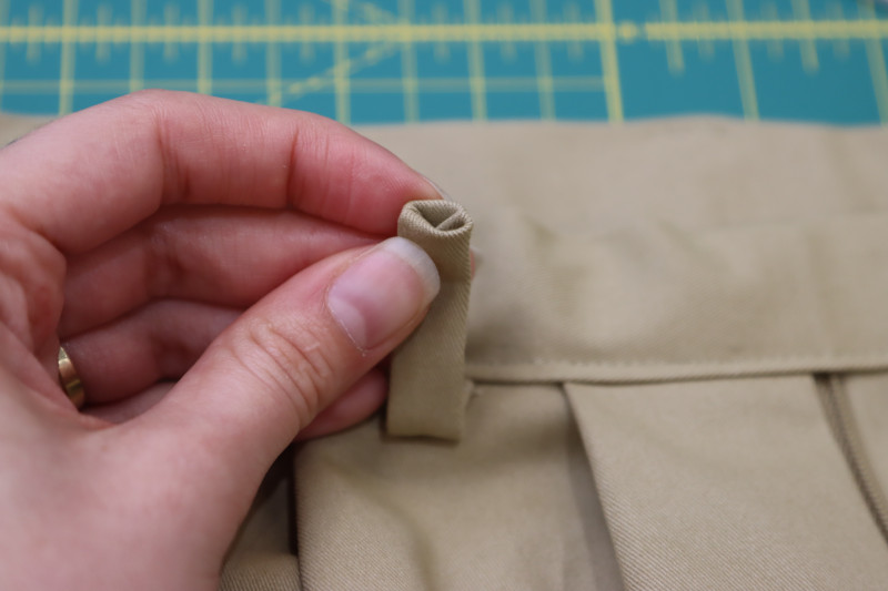 How To Tuck Raw Edges Of Belt Loops Inside Of Themselves - Stretch Khaki Twill - Mood Fabrics - Lucca Tailored Barrel Leg Pants Free Sewing Pattern Tutorial - MDF524 - Mood Fabrics Sewciety Blog - Tuck the raw edges of the belt loops inside of themselves.