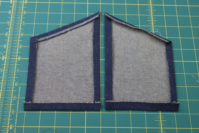 How To Fold Front Pocket Edges Folded And Pressed Wrong Side - Cotton Denim Twill - Mood Fabrics - Merit Jumpsuit Free Sewing Pattern Tutorial - MDF525 - Mood Fabrics Sewciety Blog - Fold and press the edges of the front pockets toward the wrong side of the fabric.