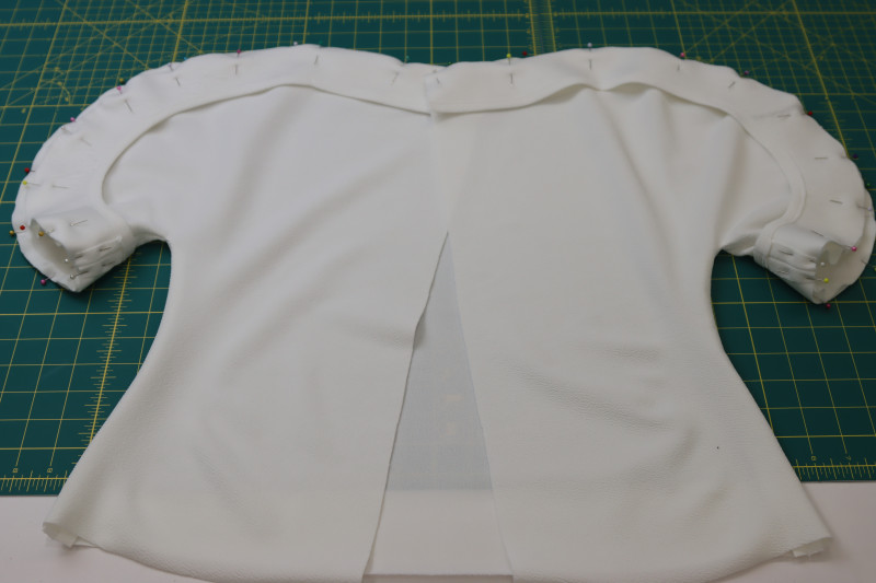 How To Pin Neckline Facings To The Neckline And Sleeves Of The Blouse - Stretch Liverpool Knit - Mood Fabrics - Merano Balloon Sleeve Blouse Free Sewing Pattern Tutorial - MDF522 - Mood Fabrics Sewciety Blog - Pin the neckline facings to the neckline and sleeves of the blouse.
