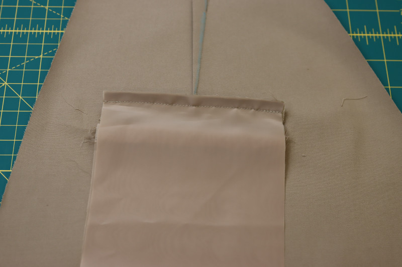 How To Pin Sew Pocket Lining To Top Welt Seam Allowance - Stretch Polester Twill Lining - Mood Fabrics - Lucca Tailored Barrel Leg Pants Free Sewing Pattern Tutorial - MDF524 - Mood Fabrics Sewciety Blog - Pin and sew the pocket lining to the top welt seam allowance.