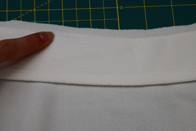 How To Trim Only The Seam Allowance For The Facings To Eliminate Bulk At The Neckline - Stretch Liverpool Knit - Mood Fabrics - Merano Balloon Sleeve Blouse Free Sewing Pattern Tutorial - MDF522 - Mood Fabrics Sewciety Blog - Trim only the seam allowance for the facings to eliminate bulk at the neckline.