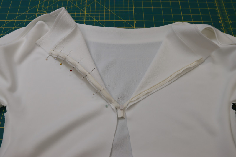 How To Pin Opposite Side Of The Zipper Tape Right Sides Together With The Opposite Side Of The Center Back Opening - Invisible Zipper - Mood Fabrics - Merano Balloon Sleeve Blouse Free Sewing Pattern Tutorial - MDF522 - Mood Fabrics Sewciety Blog - Pin the opposite side of the zipper tape right sides together with the opposite side of the center back opening.
