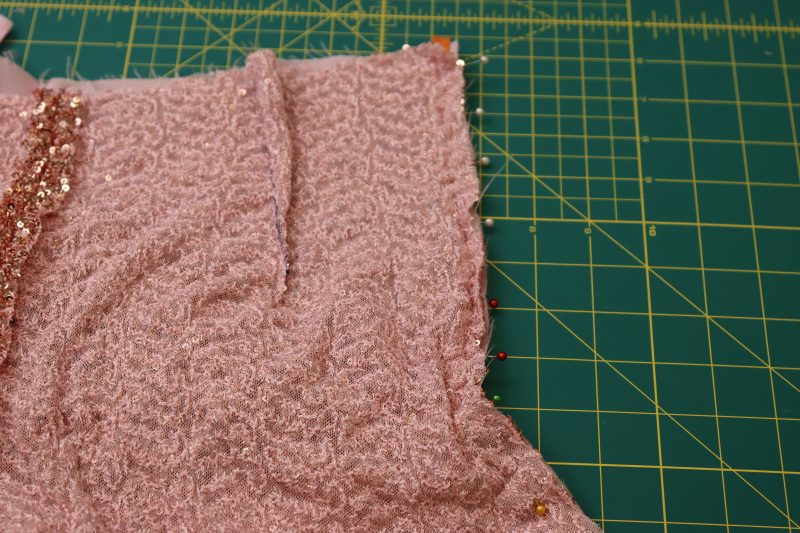 How To Pin Other Side Of Zipper Tape Between Sequined Fabric And Lining - Invisible Zipper - Mood Fabrics - Morganite Waistcoat Ensemble Free Sewing Pattern Tutorial - MDF519 - Mood Fabrics Sewciety Blog - Pin the other side of the zipper tape between the sequined fabric and the lining on the opposite side of the back crotch seam.