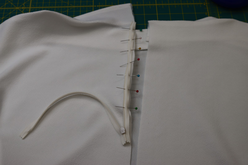 How To Pin Zipper Right Sides Together With The Wearer’s Left Side Of The Center Back Opening - Invisible Zipper - Mood Fabrics - Merano Balloon Sleeve Blouse Free Sewing Pattern Tutorial - MDF522 - Mood Fabrics Sewciety Blog - Pin the zipper right sides together with the wearer’s left side of the center back opening.