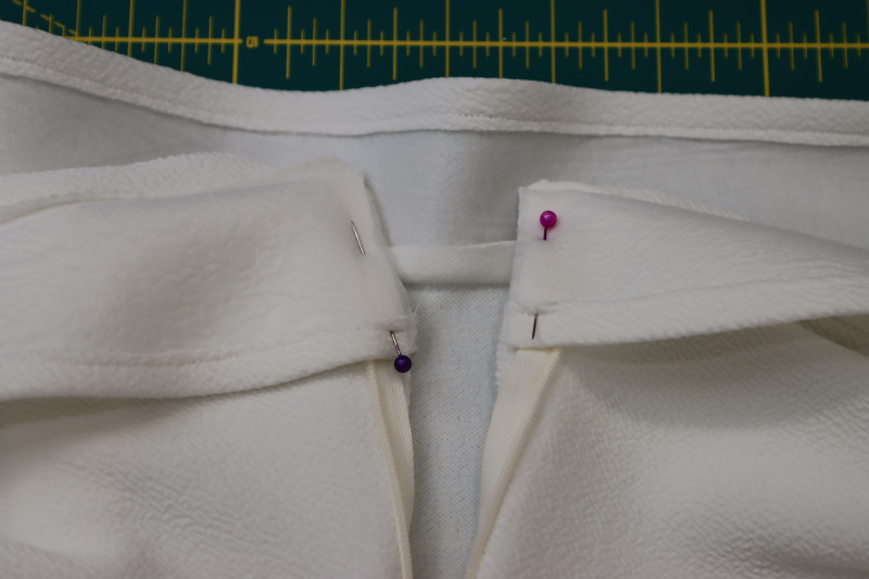 How To Pin Ends Of The Facings Right Sides Together With The Center Back Of The Blouse - Stretch Liverpool Knit - Mood Fabrics - Merano Balloon Sleeve Blouse Free Sewing Pattern Tutorial - MDF522 - Mood Fabrics Sewciety Blog - Pin the ends of the facings right sides together with the center back of the blouse.