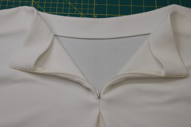How To Press Zipper And The Neckline Facings At The Center Back Of The Blouse - Stretch Liverpool Knit - Mood Fabrics - Merano Balloon Sleeve Blouse Free Sewing Pattern Tutorial - MDF522 - Mood Fabrics Sewciety Blog - Press the zipper and the neckline facings at the center back of the blouse.