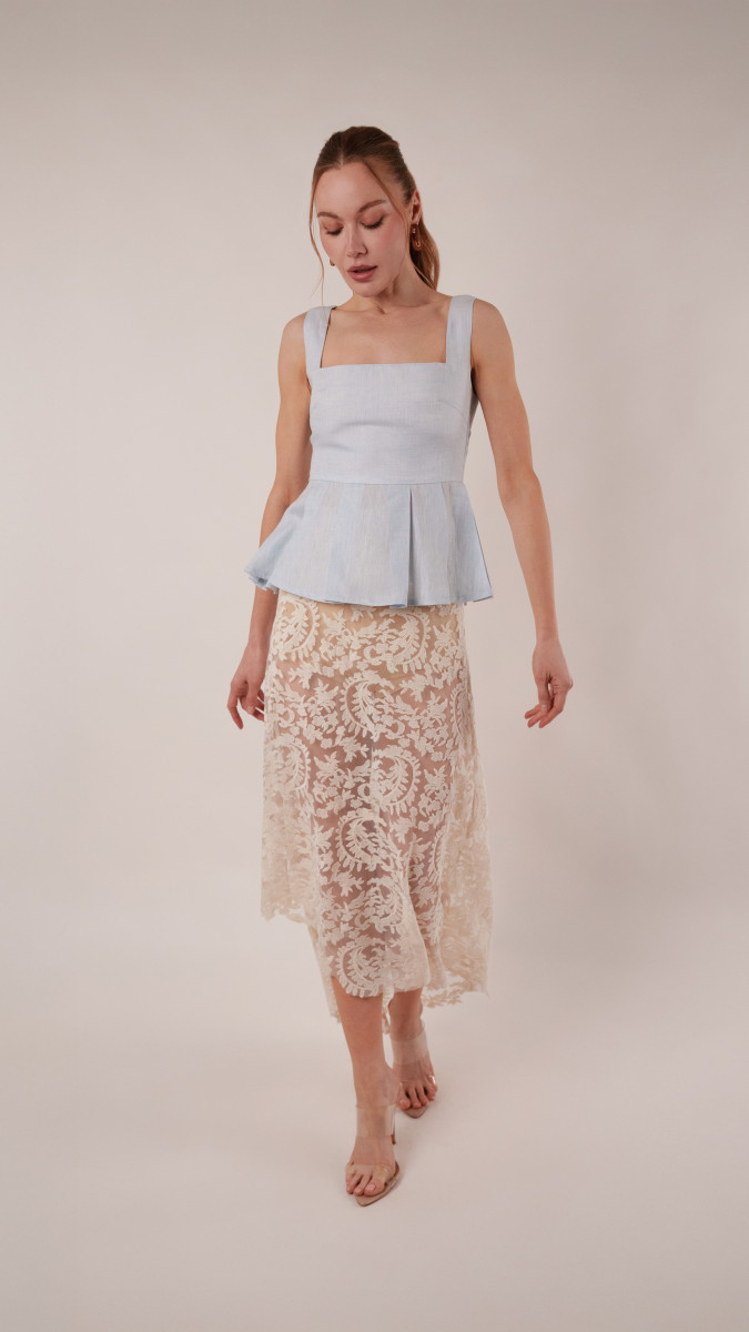 Model wearing Taiga Trapeze Skirt Sewing Pattern posing for Transitional Spring Sewing Project Ideas. Free Sewing Pattern PDF from Mood Fabrics Sewciety Blog.
