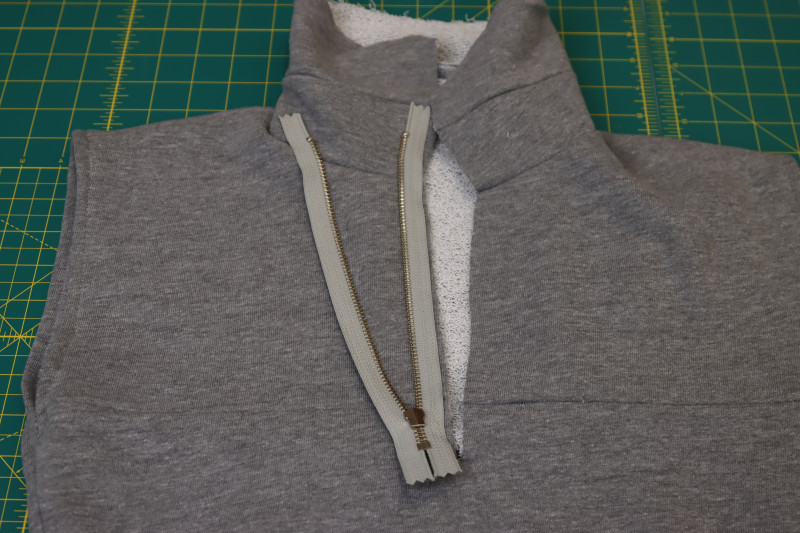 How To Sew One Side Of Zipper Right Sides Together With Neckline Slit - 9 Inch Metal Teeth Zipper - Mood Fabrics - Reef Sleeveless Cover Up Free Sewing Pattern Tutorial - MDF535 - Mood Fabrics Sewciety Blog - Sew one side of the zipper right sides together with the neckline slit.