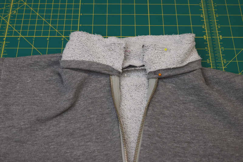 How To Pin Short Ends Of Collar Pieces Right Sides Together With Zipper Sandwiched Between Them - Heather Gray French Terry - Mood Fabrics - Reef Sleeveless Cover Up Free Sewing Pattern Tutorial - MDF535 - Mood Fabrics Sewciety Blog - Pin the short ends of the collar pieces right sides together with the zipper sandwiched between them.