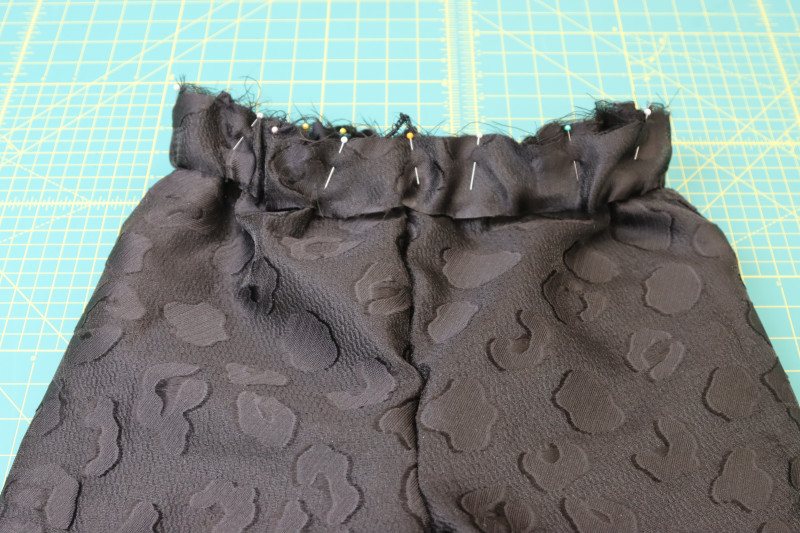 How To Pin Waistband Pants Waistline - Textured Burnout Brocade - Mood Fabrics - Matrix Shawl Collar Ensemble Free Sewing Pattern Tutorial - MDF543 - Mood Fabrics Sewciety Blog - Pin the waistband to the waistline of the pants.