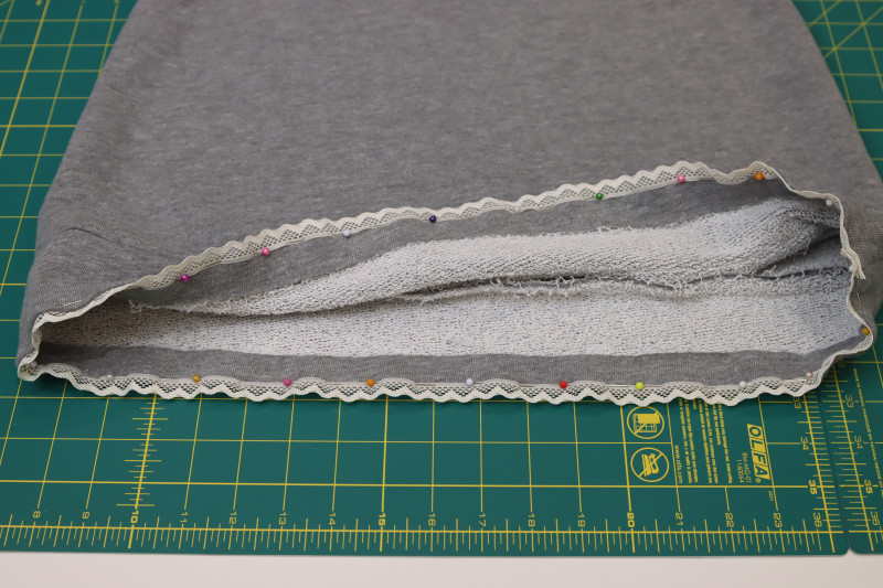 How To Pin Lace Trim To Hem Of Skirt - Scalloped Lace Trim - Mood Fabrics - Reef Sleeveless Cover Up Free Sewing Pattern Tutorial - MDF535 - Mood Fabrics Sewciety Blog - Pin the lace trim to the hem of the skirt.