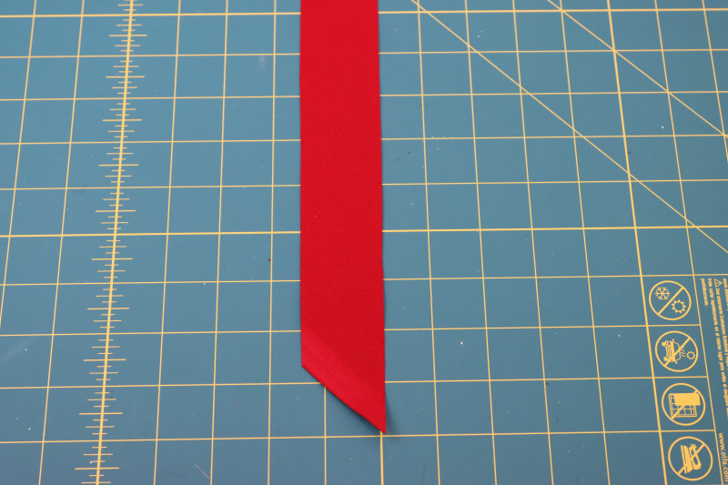 How To Cut Red Bias Tape - Red Quilting Cotton - Mood Fabrics - Matrix Shawl Collar Ensemble Free Sewing Pattern Tutorial - MDF543 - Mood Fabrics Sewciety Blog - Cut a strip of red bias tape that is 1.5 inches wide.