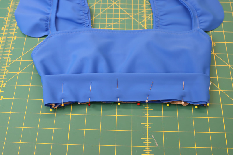 How To Pin Waistband To Bottom Of Bikini Top Right Sides Together - Recycled Swimwear Tricot - Mood Fabrics - Azure Tankini Skirt Set Free Sewing Pattern Tutorial - MDF533 - Mood Fabrics Sewciety Blog - Pin the waistband to the bottom of the bikini top, right sides together.