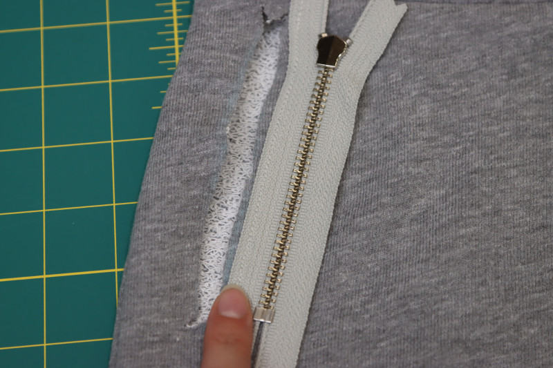 How To Sew Zipper Right Sides Together With Inner Edge Of Pocket Slit - 4.5 Inch Metal Teeth Zipper - Mood Fabrics - Reef Sleeveless Cover Up Free Sewing Pattern Tutorial - MDF535 - Mood Fabrics Sewciety Blog - Sew the zipper right sides together with the inner edge of the pocket slit.