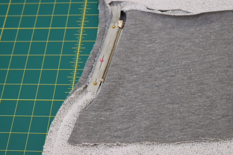 How To Pin Sew Other Side Of Zipper Tape On Both Zippers To Other Side Of Pocket Slit - 4.5 Inch Metal Teeth Zipper - Mood Fabrics - Reef Sleeveless Cover Up Free Sewing Pattern Tutorial - MDF535 - Mood Fabrics Sewciety Blog - Pin and sew the other side of the zipper tape on both zippers to the other side of each pocket slit right sides together.