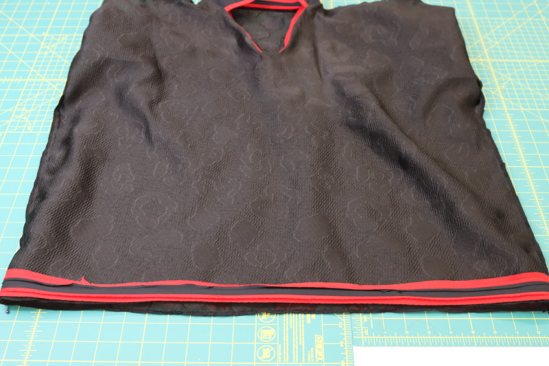 How To Pin Sew Trim Wrong Side Shirt Hem - Red Quilting Cotton - Mood Fabrics - Matrix Shawl Collar Ensemble Free Sewing Pattern Tutorial - MDF543 - Mood Fabrics Sewciety Blog - Pin and sew the trim to the wrong side of the shirt hem.