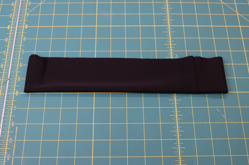 How To Fold Waistband In Half Longways To Hide Seam Allowance - Recycled Swimwear Tricot - Mood Fabrics - Antikythera One Shoulder Bikini Free Sewing Pattern Tutorial - MDF531 - Mood Fabrics Sewciety Blog - Fold the waistband in half longways to hide the seam allowance on the inside.