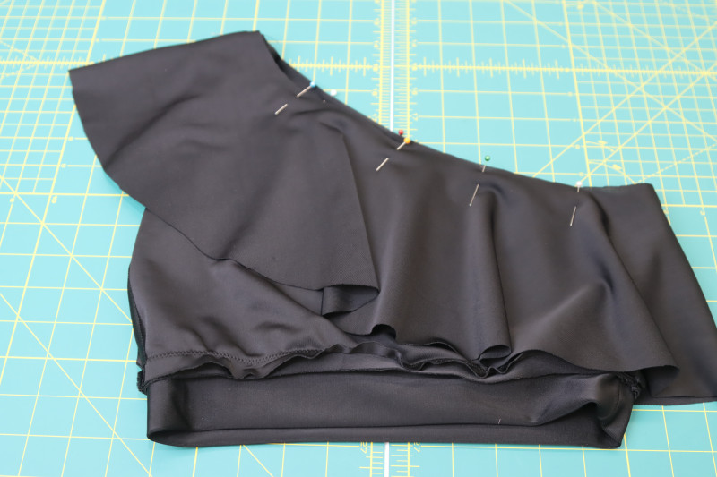 How To Pin Sew Right Side Of Ruffle To Wrong Side Of Bikini Neckline - Recycled Swimwear Tricot - Mood Fabrics - Antikythera One Shoulder Bikini Free Sewing Pattern Tutorial - MDF531 - Mood Fabrics Sewciety Blog - Pin and sew the right side of the ruffle to the wrong side of the bikini neckline.