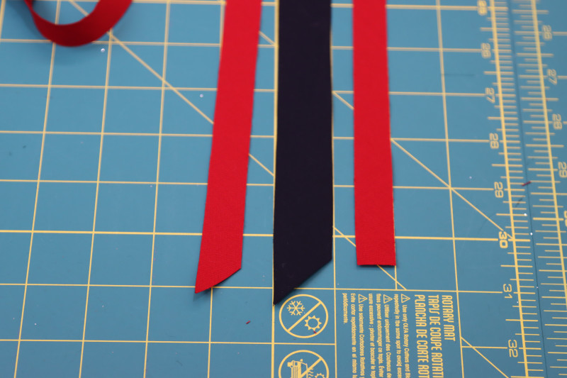 How To Cut Bias Tape Strips - Red Quilting Cotton - Mood Fabrics - Matrix Shawl Collar Ensemble Free Sewing Pattern Tutorial - MDF543 - Mood Fabrics Sewciety Blog - Cut your strips of bias tape.
