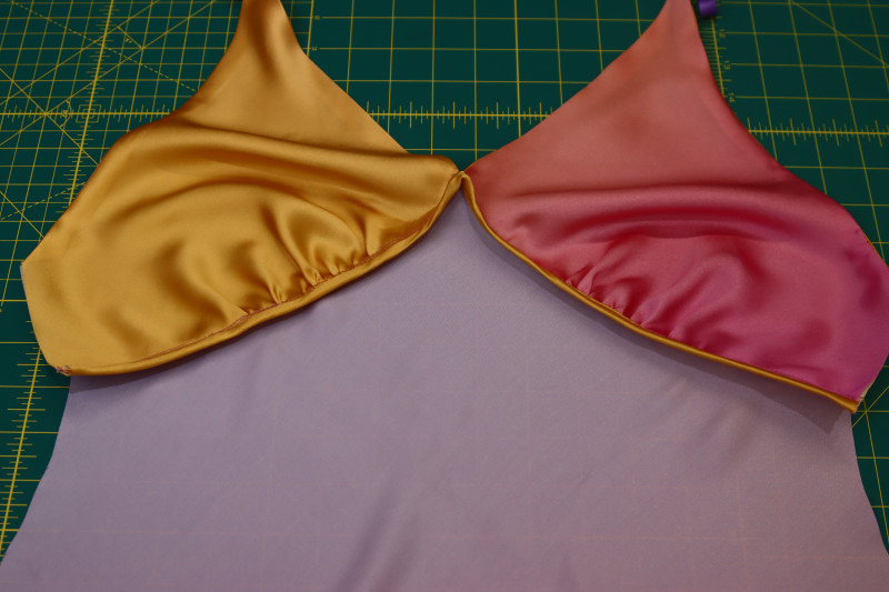 How To Wrap Bias Tape Around Seam Allowance Sew Down - Silk Charmeuse Print - Mood Fabrics - Alexandrite Sunset Silk Charmeuse Dress Free Sewing Pattern Tutorial - MDF529 - Mood Fabrics Sewciety Blog - Wrap the bias tape around the seam allowance and sew it down.