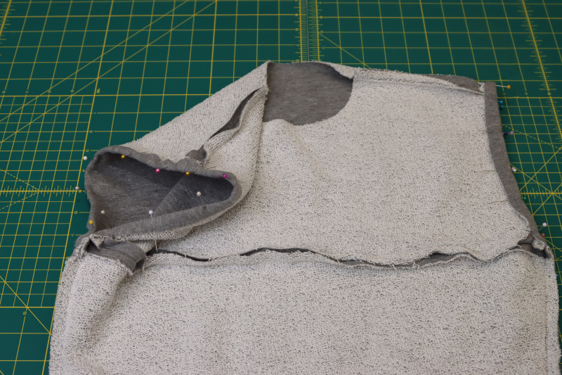How To Pin Hem Into Armscyes - Heather Gray French Terry - Mood Fabrics - Reef Sleeveless Cover Up Free Sewing Pattern Tutorial - MDF535 - Mood Fabrics Sewciety Blog - Pin the hem into the armscyes.