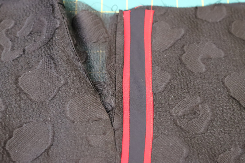 How To Topstitch Trim Other Edge - Red Quilting Cotton - Mood Fabrics - Matrix Shawl Collar Ensemble Free Sewing Pattern Tutorial - MDF543 - Mood Fabrics Sewciety Blog - Topstitch the other edge of the trim to the side of the pants.