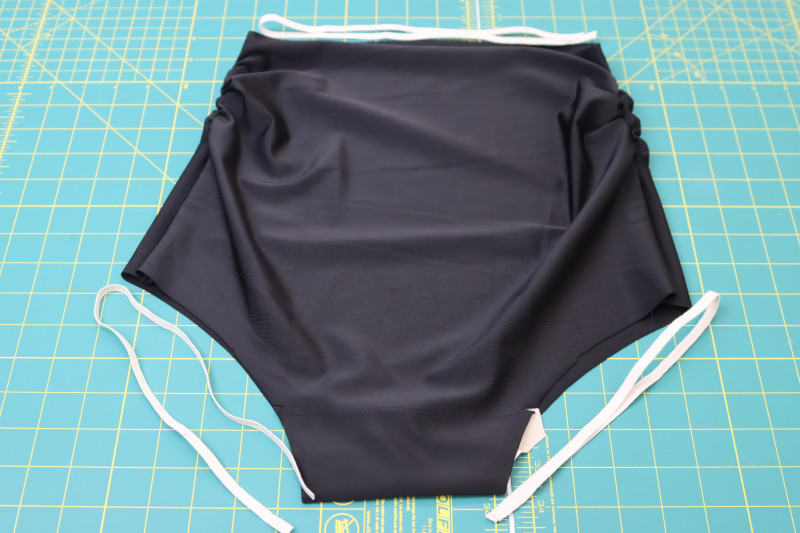 How To Cut Swimsuit Elastic To Length Of Bikini Bottom Openings - Cotton Swimwear Elastic - Mood Fabrics - Antikythera One Shoulder Bikini Free Sewing Pattern Tutorial - MDF531 - Mood Fabrics Sewciety Blog - Cut the swimsuit elastic to the length of the bikini bottom openings.