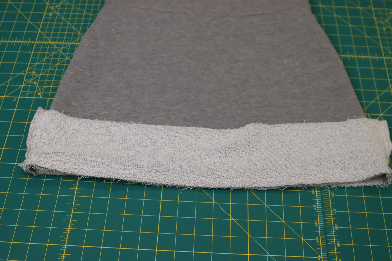 How To Sew Hem Band To Hem Of Skirt - Heather Gray French Terry - Mood Fabrics - Reef Sleeveless Cover Up Free Sewing Pattern Tutorial - MDF535 - Mood Fabrics Sewciety Blog - Sew the hem band to the hem of the skirt.