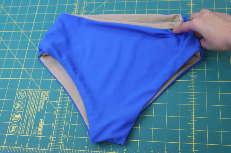 How To Flip Bikini Bottoms Right Sides Out Through Hole In Waistline - Recycled Swimwear Tricot - Mood Fabrics - Azure Tankini Skirt Set Free Sewing Pattern Tutorial - MDF533 - Mood Fabrics Sewciety Blog - Flip the bikini bottoms right sides out through the hole in the waistline.