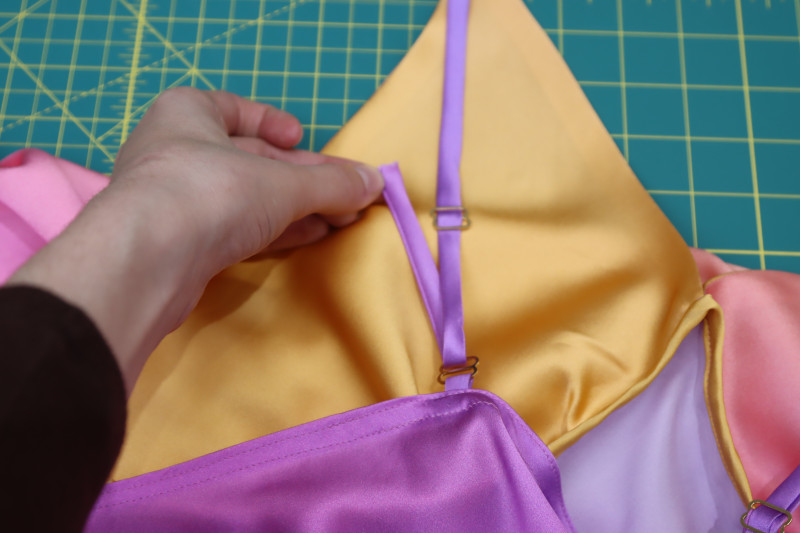 How To Insert Front Strap Top Loop Back Adjuster - Gold Metal Strap Sliders - Mood Fabrics - Alexandrite Sunset Silk Charmeuse Dress Free Sewing Pattern Tutorial - MDF529 - Mood Fabrics Sewciety Blog - Insert the front strap into the top loop of the back adjuster.