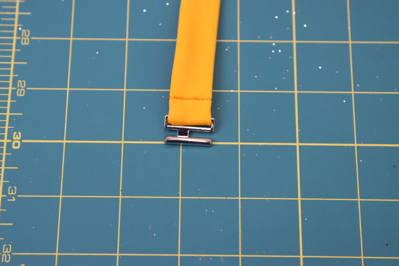 How To Insert Belt End Bikini Clasp - Bikini Belt Clasp - Mood Fabrics - Amber Two Piece Cheeky Swimsuit Free Sewing Pattern Tutorial - MDF540 - Mood Fabrics Sewciety Blog - Insert the end of the belt into the bikini clasp and topstitch over it to secure.