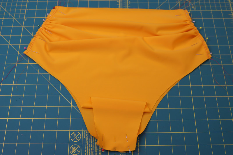 How To Pin Main Fabric Bottom Side Crotch Seams - UV Protective Swimwear Tricot - Mood Fabrics - Amber Two Piece Cheeky Swimsuit Free Sewing Pattern Tutorial - MDF540 - Mood Fabrics Sewciety Blog - Pin the front and back main fabric bottom pieces together at the side and crotch seams.