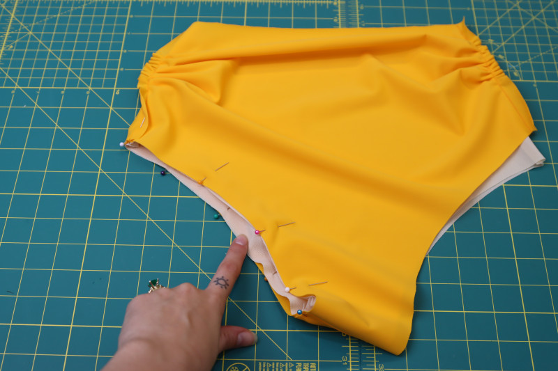 How To Pin Lining Main Fabric Leg Hole - Nude Powernet Mesh - Mood Fabrics - Amber Two Piece Cheeky Swimsuit Free Sewing Pattern Tutorial - MDF540 - Mood Fabrics Sewciety Blog - Pin the lining and main fabric pieces right sides together around one of the leg holes.