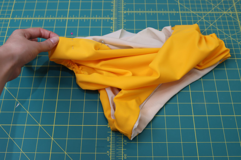 How To Pin Lining Main Fabric Other Leg Hole - Nude Powernet Mesh - Mood Fabrics - Amber Two Piece Cheeky Swimsuit Free Sewing Pattern Tutorial - MDF540 - Mood Fabrics Sewciety Blog - Pin the lining and main fabric in the other leg hole right sides together.