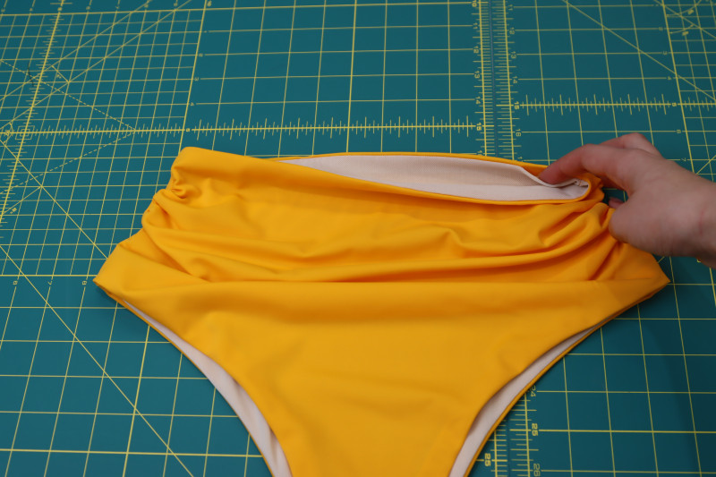 How To Flip Bikini Bottoms Through Waistline Hole - UV Protective Swimwear Tricot - Mood Fabrics - Amber Two Piece Cheeky Swimsuit Free Sewing Pattern Tutorial - MDF540 - Mood Fabrics Sewciety Blog - Flip the bikini bottoms right sides out through the hole in the waistline.