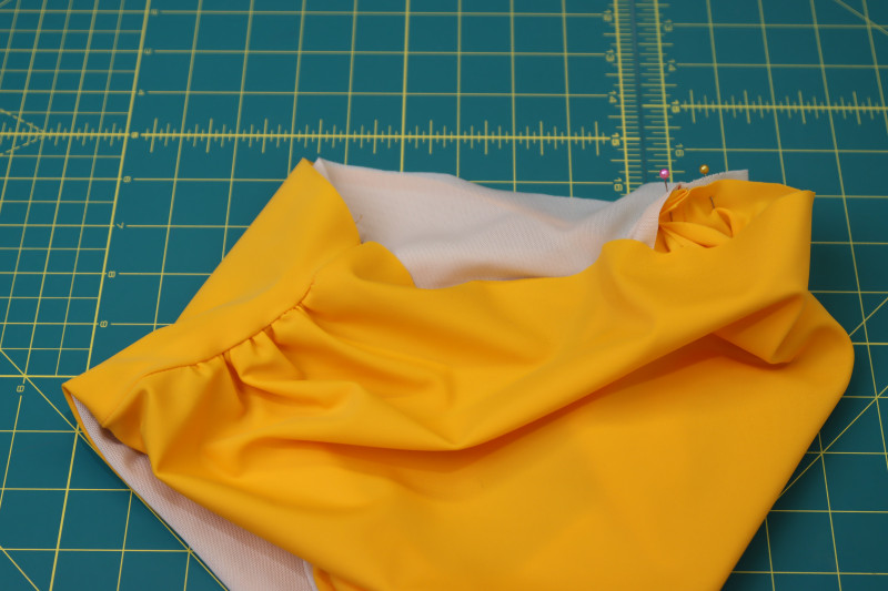 How To Pin Bikini Bottom Waistline - UV Protective Swimwear Tricot - Mood Fabrics - Amber Two Piece Cheeky Swimsuit Free Sewing Pattern Tutorial - MDF540 - Mood Fabrics Sewciety Blog - Pin the main fabric and lining right sides together around the waistline of the bikini bottoms.