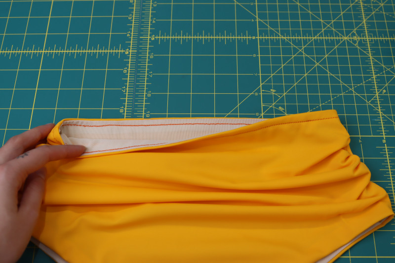 How To Topstitch Bikini Bottom Waistline - Gutermann Sew All Thread - Mood Fabrics - Amber Two Piece Cheeky Swimsuit Free Sewing Pattern Tutorial - MDF540 - Mood Fabrics Sewciety Blog - Topstitch over the waistline to close the hole and secure the lining to the inside of the bikini bottoms.