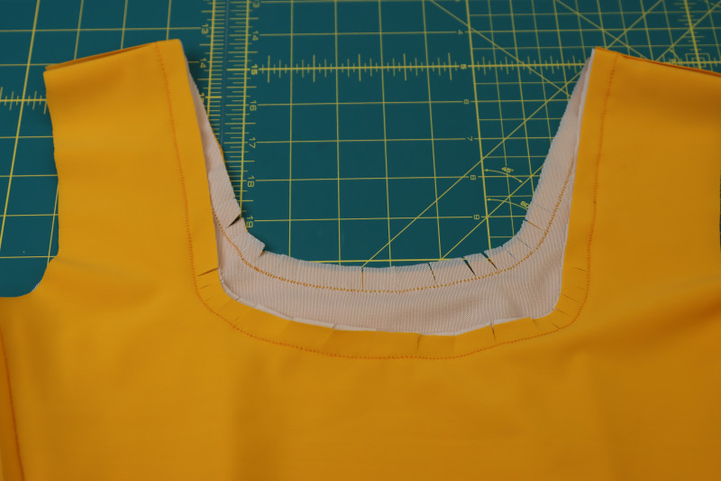 How To Clip Neckline Rounded Corners - UV Protective Swimwear Tricot - Mood Fabrics - Amber Two Piece Cheeky Swimsuit Free Sewing Pattern Tutorial - MDF540 - Mood Fabrics Sewciety Blog - Clip the rounded corners of the neckline.
