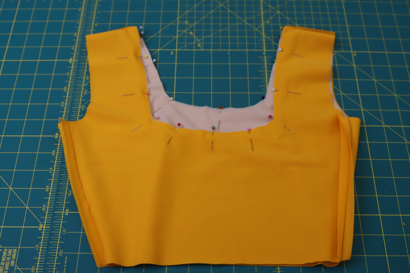 How To Pin Sew Lining Main Fabric Necklines - Nude Powernet Mesh - Mood Fabrics - Amber Two Piece Cheeky Swimsuit Free Sewing Pattern Tutorial - MDF540 - Mood Fabrics Sewciety Blog - Pin and sew the lining and main fabric necklines right sides together.