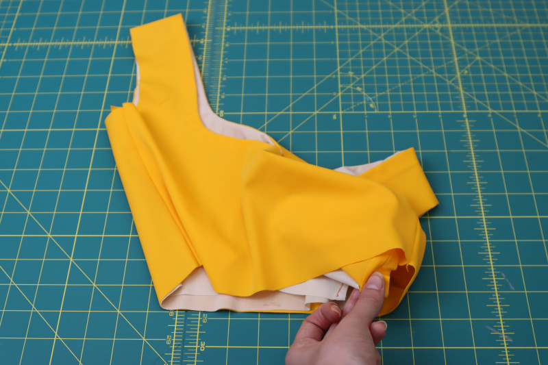 How To Pull Underarm Fabric Bottom Hem - Nude Powernet Mesh - Mood Fabrics - Amber Two Piece Cheeky Swimsuit Free Sewing Pattern Tutorial - MDF540 - Mood Fabrics Sewciety Blog - Pull the underarm fabric out through the bottom hem of the top.